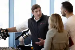 T3DMC specialist demonstrating handheld 3D scanner to visitors during a live consultation