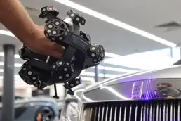 3D scanning Rolls-Royce front grille using SCANTECH handheld device during T3DMC automotive training session